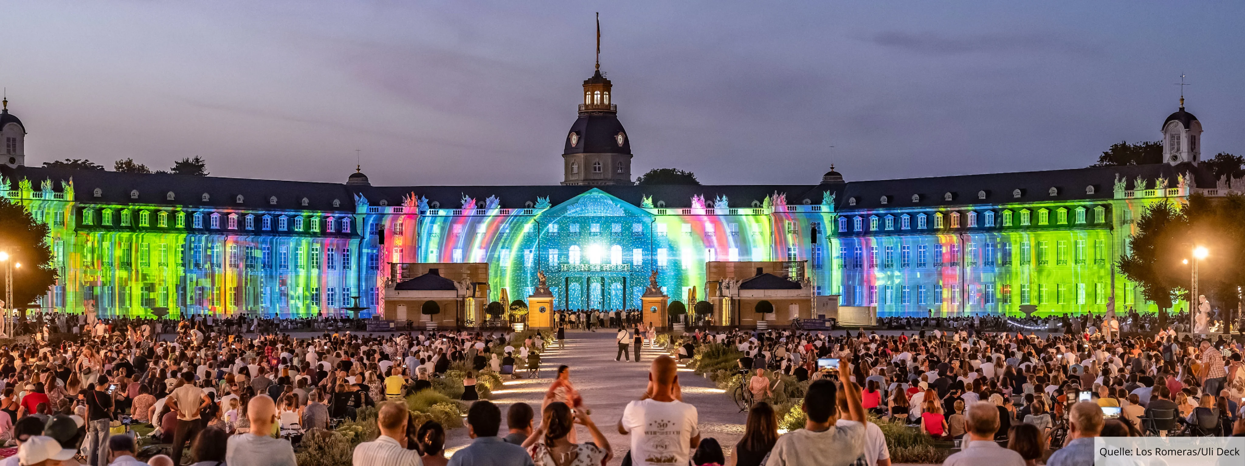 Projection Mapping auf der 170 Meter langen Fassade des Karlsruher Schlosses, davor tausende Besucher:innen der SCHLOSSLICHTSPIELE