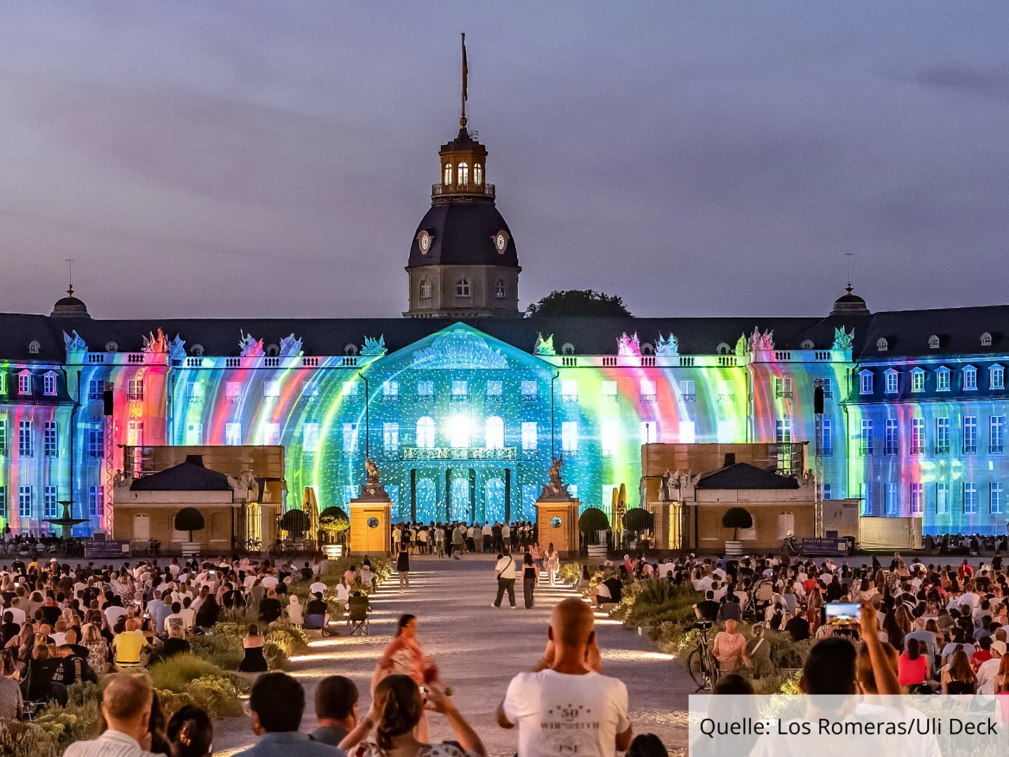 Projection Mapping auf der 170 Meter langen Fassade des Karlsruher Schlosses, davor tausende Besucher:innen der SCHLOSSLICHTSPIELE